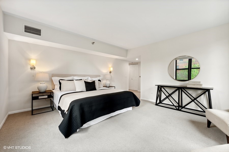 55 West Delaware Place, Unit 415 Chicago, IL 60610 - Photo 20 of 41 a bedroom with a bed a dresser and chair
