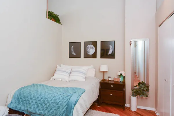 a bedroom with a bed and a potted plant