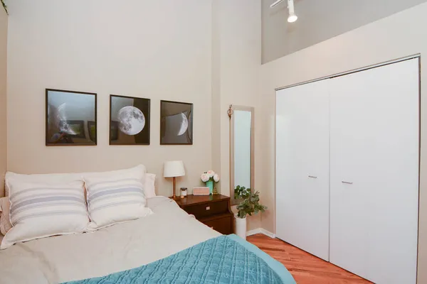 a bedroom with a bed and wooden floor