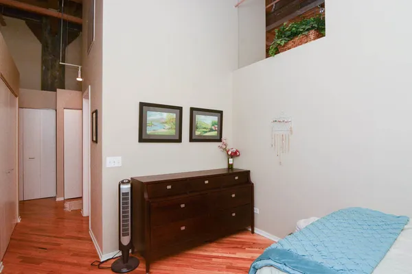 a view of a bedroom with wooden floor and cabinet