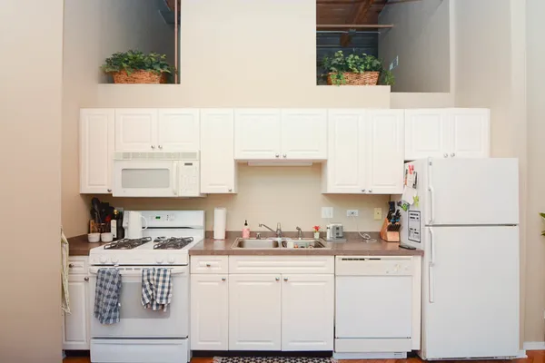 a kitchen with granite countertop white cabinets and white appliances