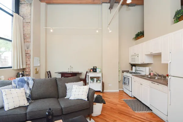 a living room with furniture and view of kitchen