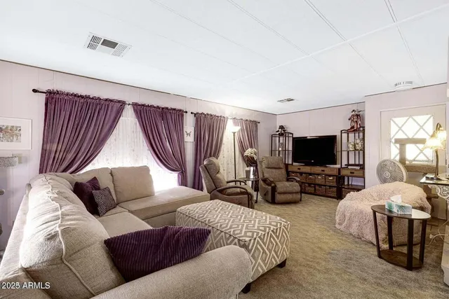 a living room with furniture a flat screen tv and a large window