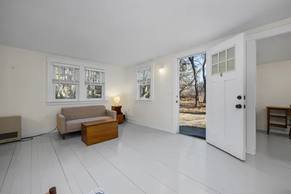 a living room with furniture wooden floor and dining table