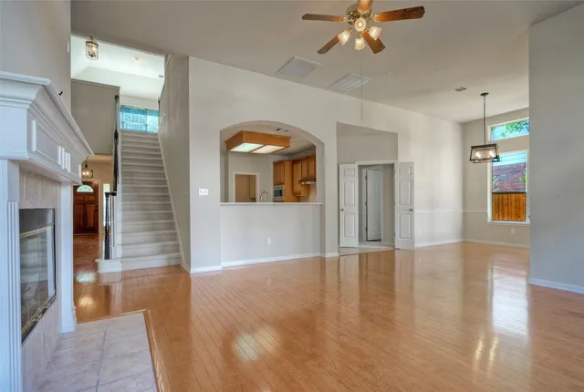 a view of an empty room with window and wooden floor