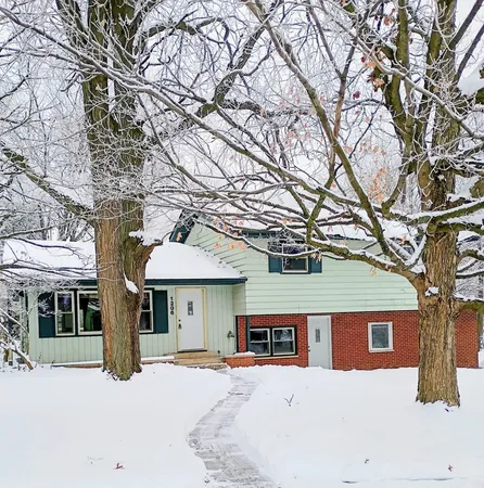 a front view of a building with large trees
