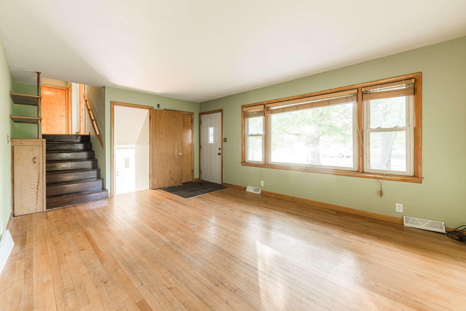 1206 University Drive DeKalb, IL 60115 - Photo 2 of 16 a view of an empty room with wooden floor and a window