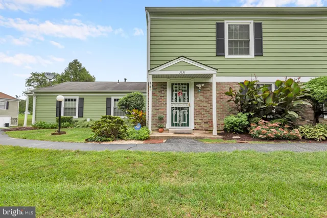 a front view of a house with a yard and potted plants
