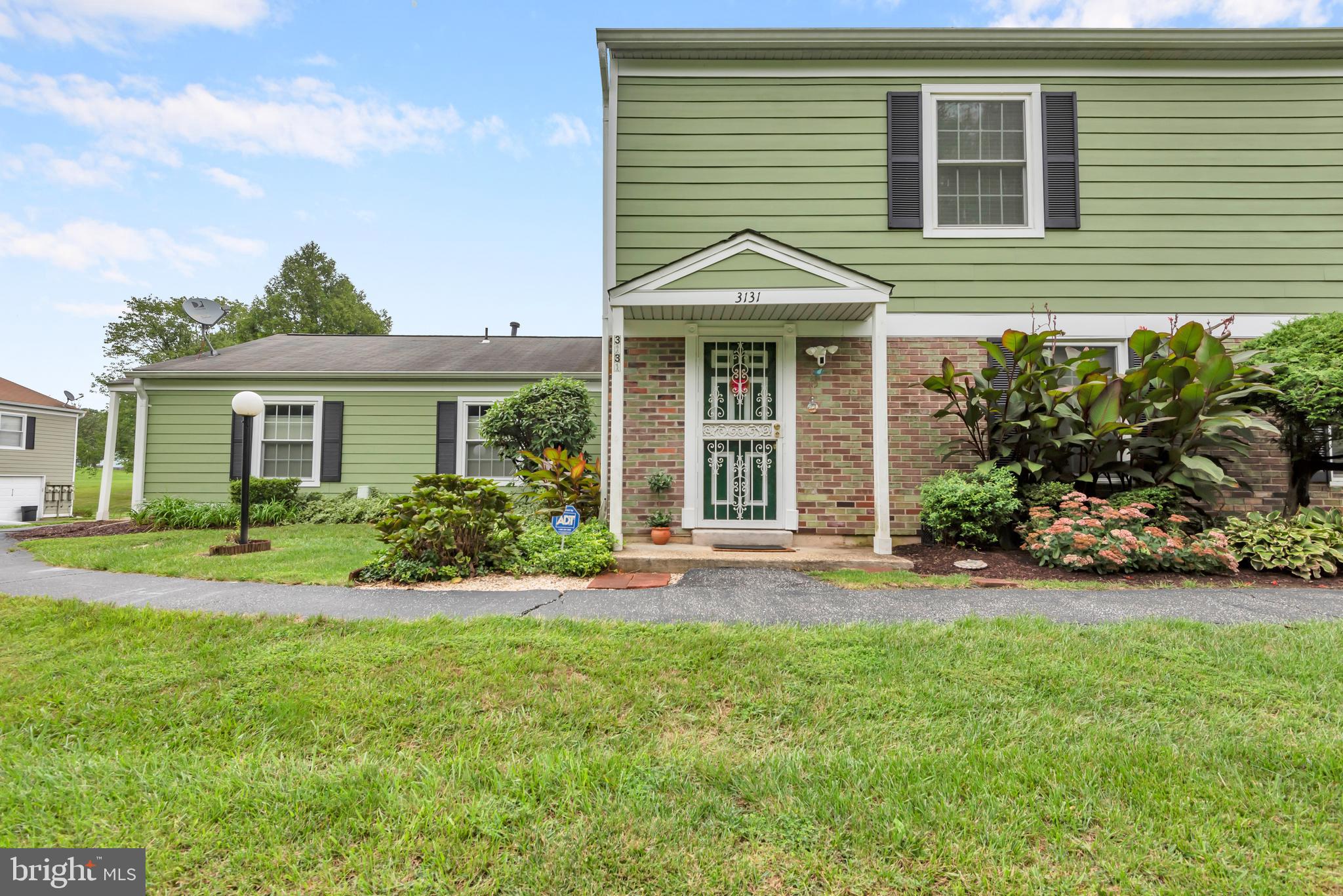 a front view of a house with a yard and potted plants
