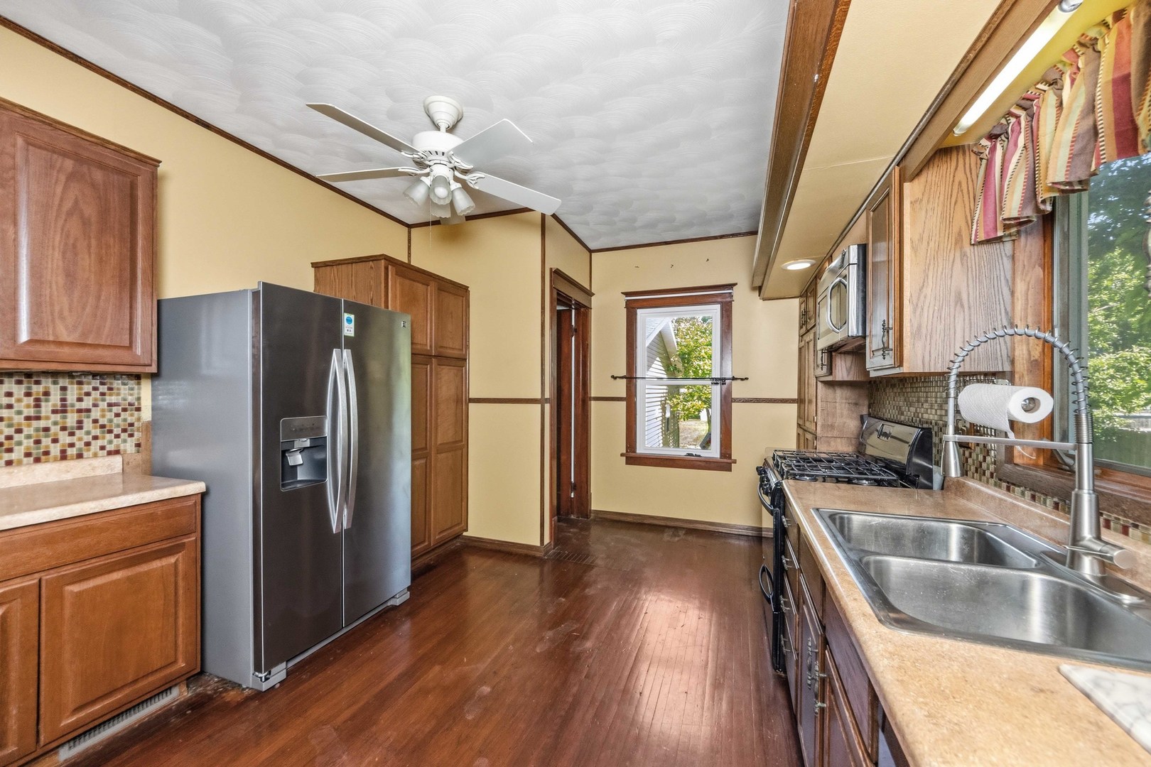 412 West 5th Street Minonk, IL 61760 - Photo 10 of 23 a kitchen with stainless steel appliances granite countertop a refrigerator a sink dishwasher a stove and white countertops with wooden floor