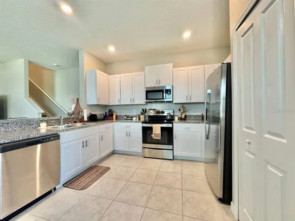 a kitchen with stainless steel appliances granite countertop a refrigerator and a stove top oven