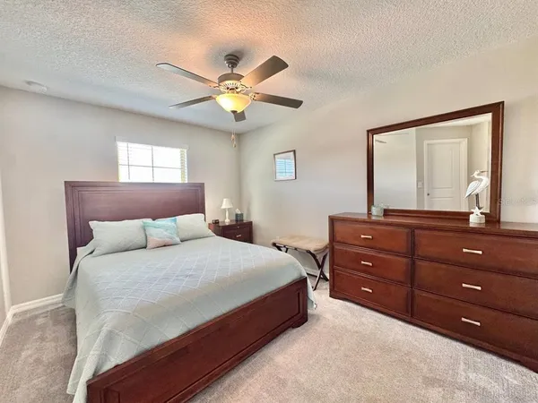 a bedroom with a bed and a mirror on dresser