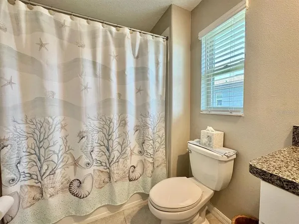 a white toilet sitting next to a shower curtain