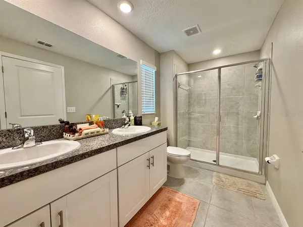 a bathroom with a double vanity sink toilet and shower