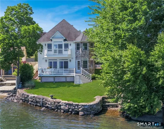 a view of a house with a big yard and large trees