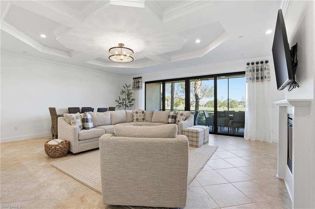 8773 Bellano Court, Unit 103 Naples, FL 34119 - Photo 11 of 47 Living area featuring coffered ceiling, a chandelier, beamed ceiling, a fireplace, and light tile patterned floors