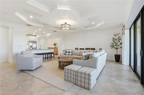a living room with furniture and a view of kitchen