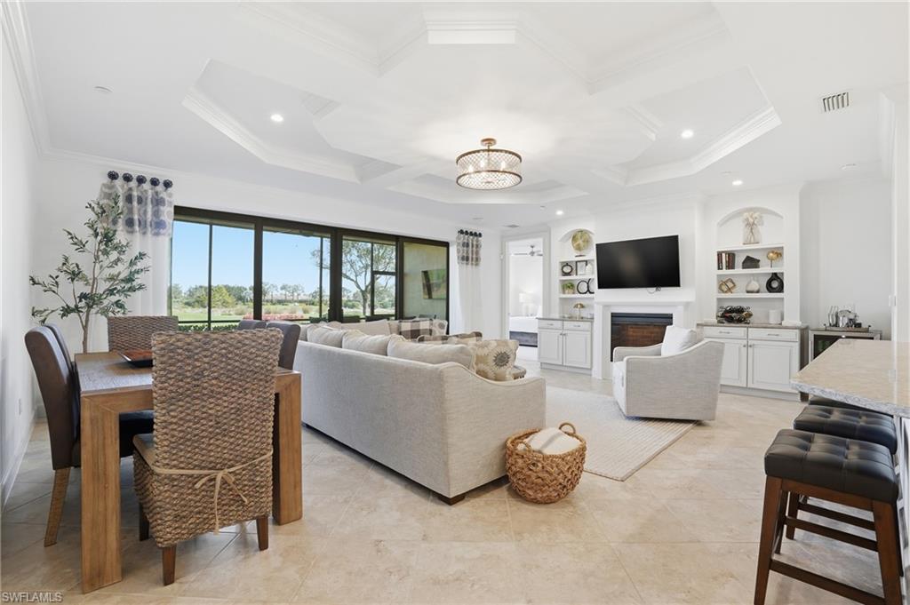 8773 Bellano Court, Unit 103 Naples, FL 34119 - Photo 17 of 47 Living area with built in shelves, a fireplace, a chandelier, coffered ceiling, and recessed lighting