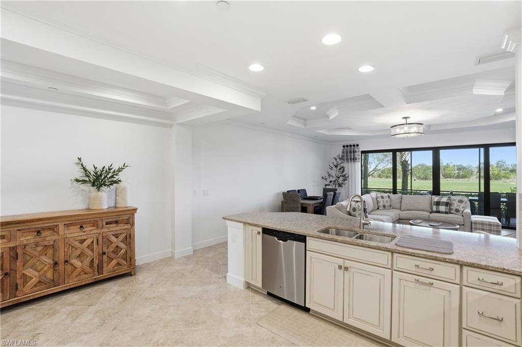 8773 Bellano Court, Unit 103 Naples, FL 34119 - Photo 46 of 47 Kitchen with light stone counters, stainless steel dishwasher, open floor plan, crown molding, and recessed lighting