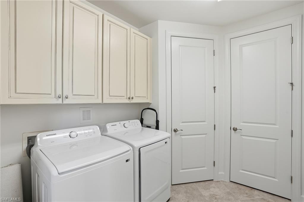 8773 Bellano Court, Unit 103 Naples, FL 34119 - Photo 30 of 47 Washroom featuring cabinet space and washing machine and clothes dryer