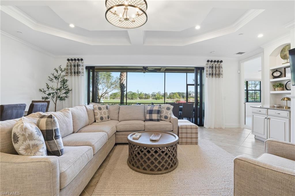 8773 Bellano Court, Unit 103 Naples, FL 34119 - Photo 10 of 47 Living area featuring plenty of natural light, a chandelier, light tile patterned floors, crown molding, and recessed lighting