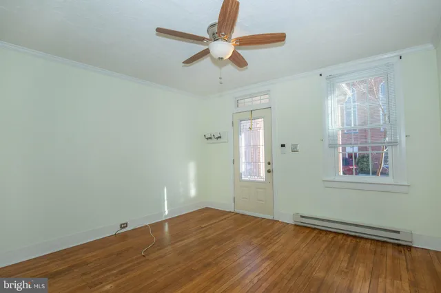 an empty room with wooden floor a ceiling fan and closet