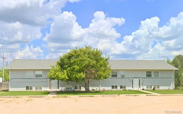 a view of a house with a big yard and large trees