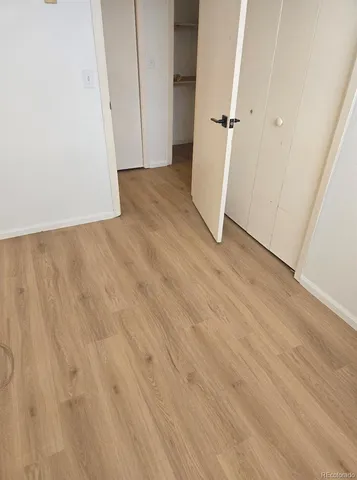 an empty room with wooden floor and white wall