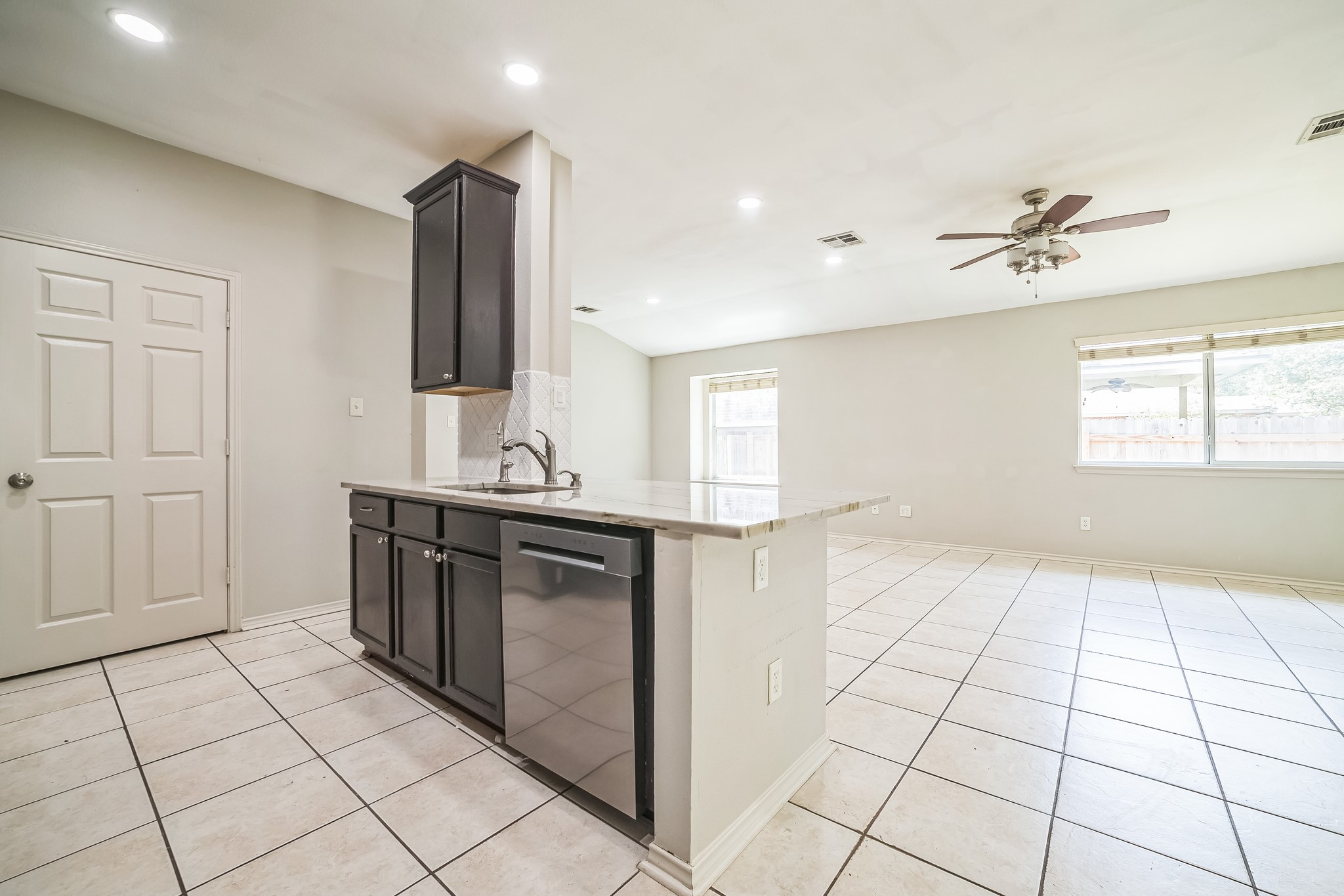 3630 Spring Canyon Trail Round Rock, TX 78681 - Photo 22 of 23 Kitchen with light stone countertops, light tile patterned floors, dishwasher, ceiling fan, and open floor plan