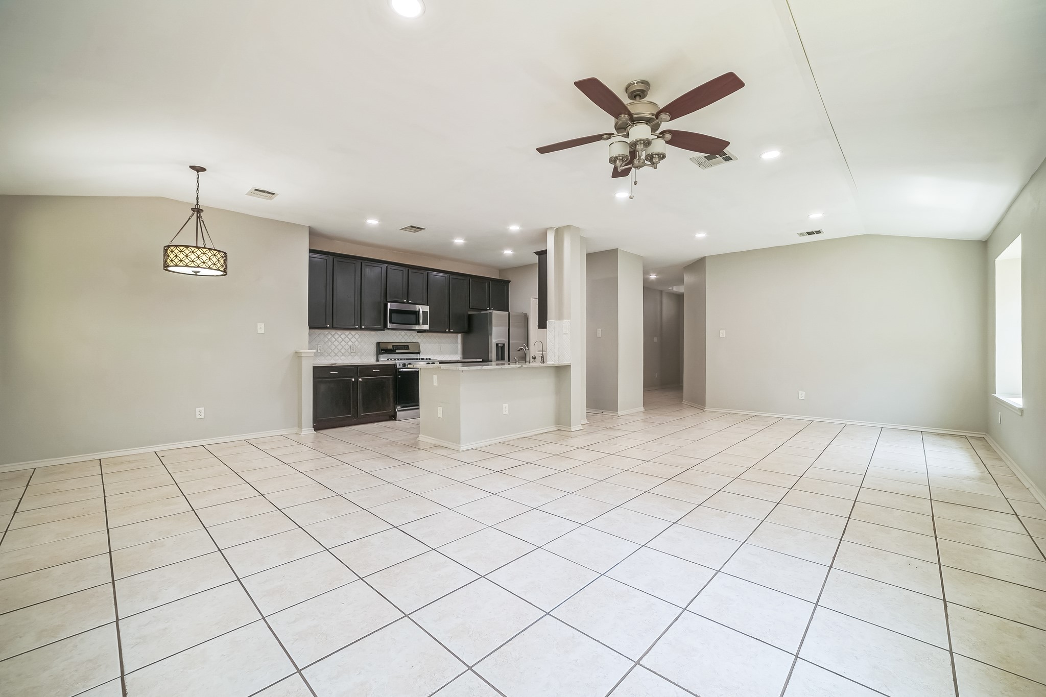 3630 Spring Canyon Trail Round Rock, TX 78681 - Photo 23 of 23 Kitchen with open floor plan, ceiling fan, lofted ceiling, dark cabinetry, and stainless steel appliances