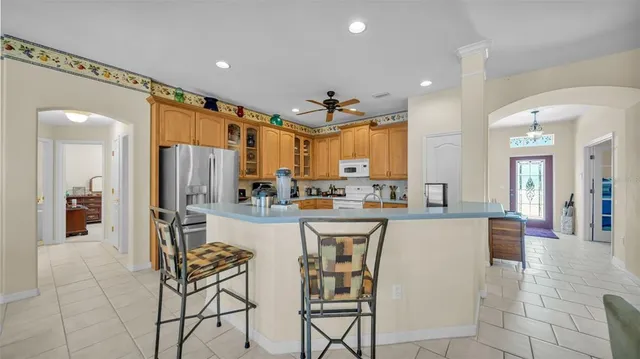 a kitchen with stainless steel appliances a refrigerator a sink dishwasher and a dining table with wooden floor