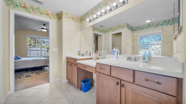 a en suite bathroom with a granite countertop double vanity sink and a mirror