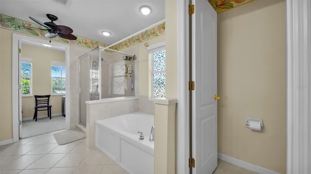 a spacious bathroom with a tub shower and a sink