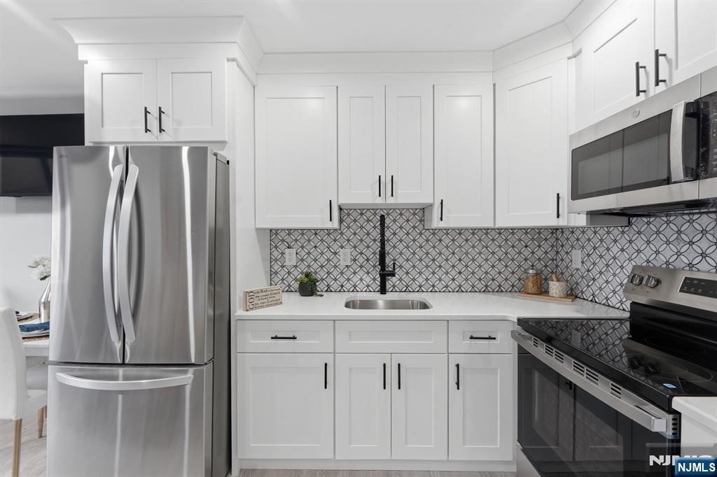 9 Vreeland Street, Unit 2F Hackensack, NJ 07601 - Photo 2 of 20 a kitchen with white cabinets sink and stainless steel appliances
