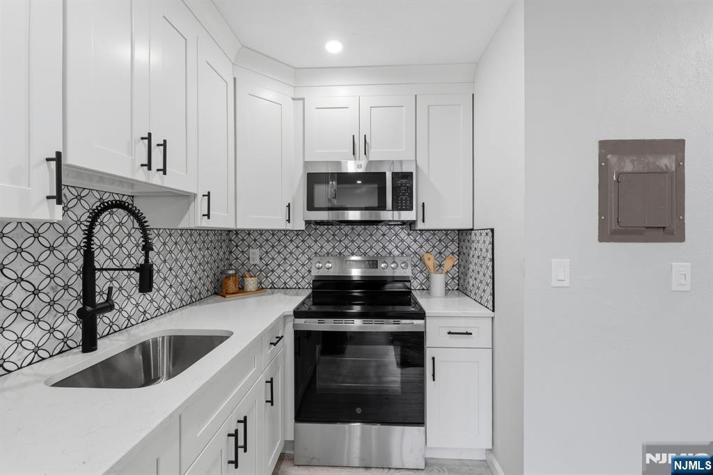 9 Vreeland Street, Unit 2F Hackensack, NJ 07601 - Photo 3 of 20 a kitchen with granite countertop a stove sink and microwave