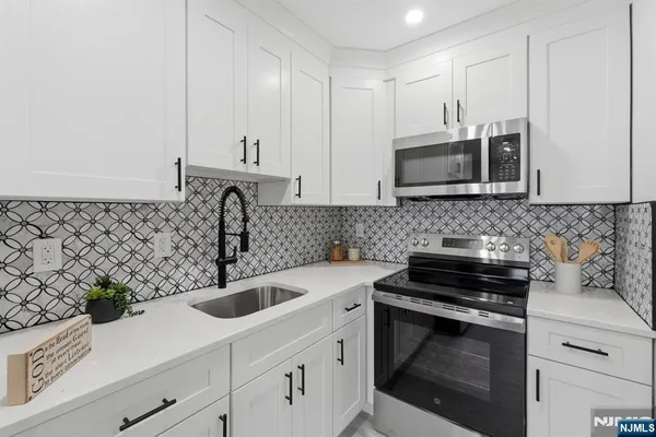a kitchen with sink a microwave and cabinets