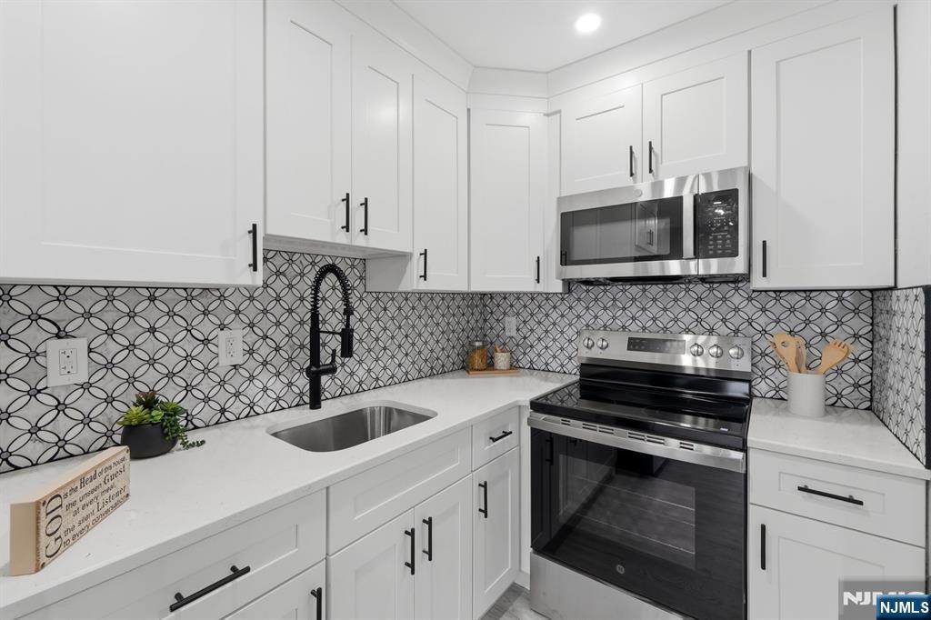 9 Vreeland Street, Unit 2F Hackensack, NJ 07601 - Photo 4 of 20 a kitchen with sink a microwave and cabinets