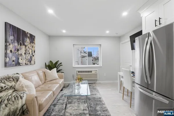a living room with furniture and a refrigerator