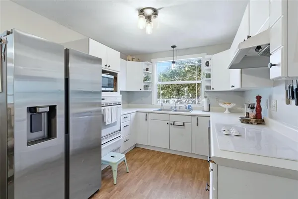 a kitchen with refrigerator cabinets and wooden floor