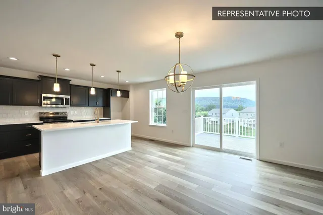 a kitchen with kitchen island a sink stainless steel appliances and cabinets
