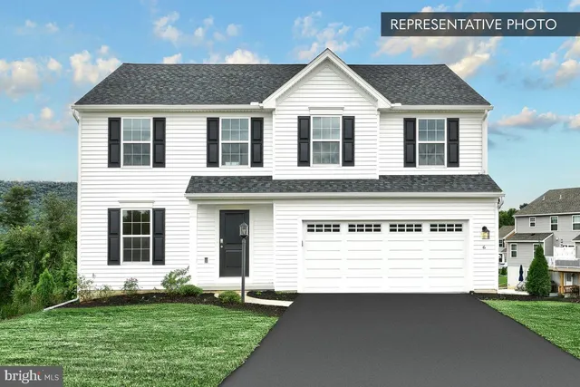 a view of a white house with a small yard and large trees
