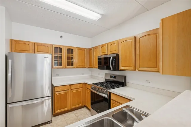 a kitchen with stainless steel appliances granite countertop a refrigerator stove top oven and sink