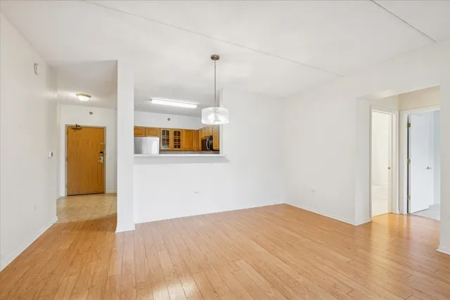 a view of a room with wooden floor and a ceiling fan