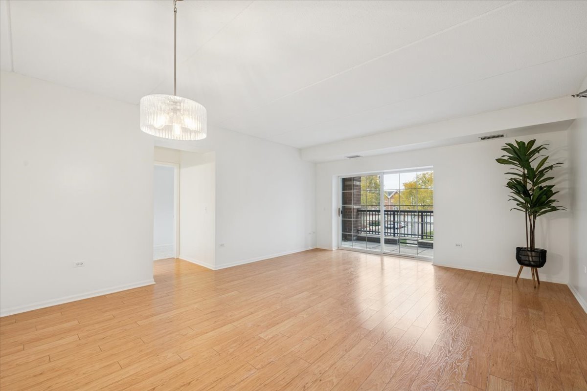 440 West Mahogany Court, Unit 203 Palatine, IL 60067 - Photo 7 of 17 a view of an empty room with wooden floor and a window