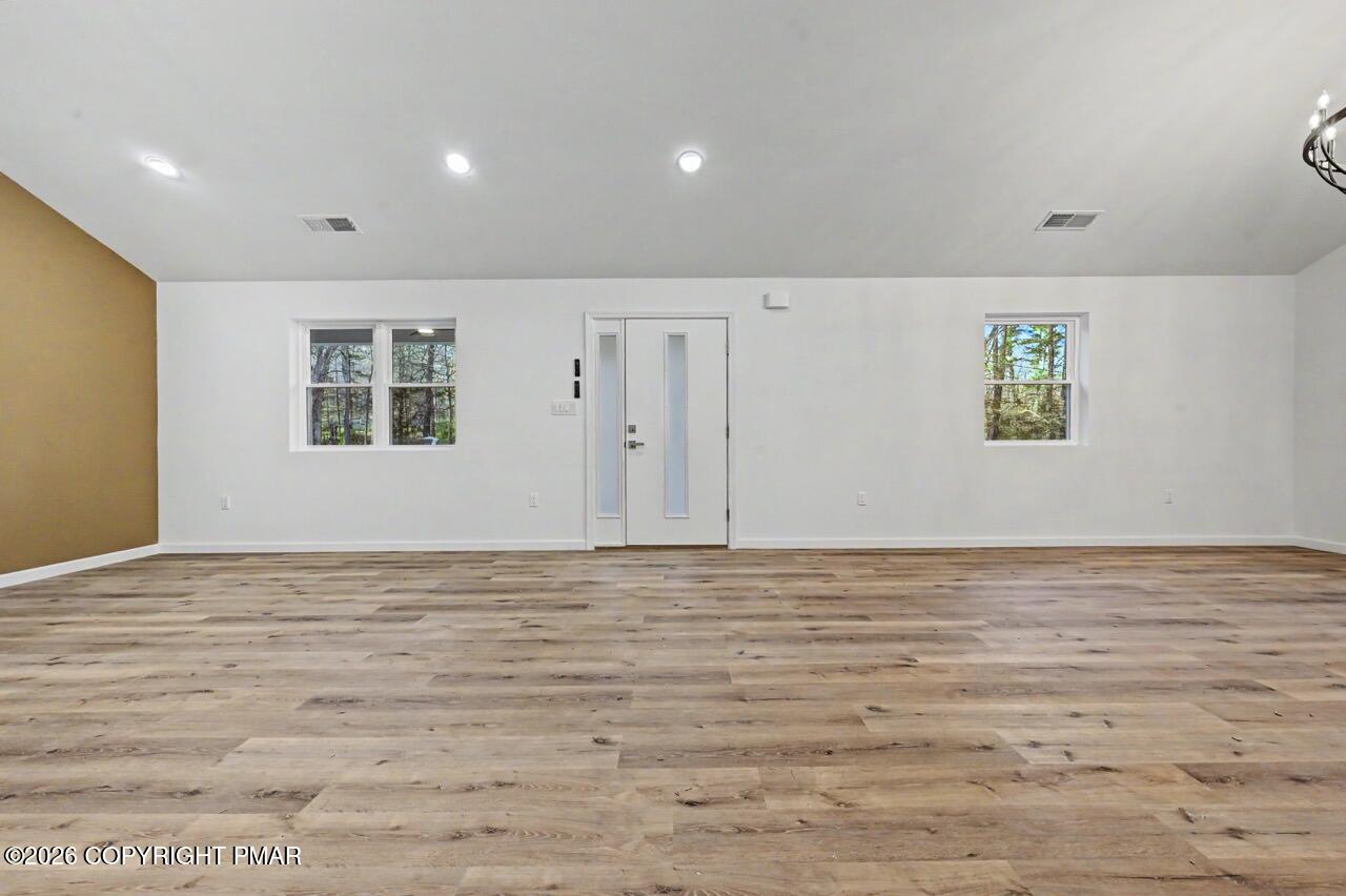 1131 Mink Court Bushkill, PA 18324 - Photo 15 of 81 a view of an empty room with wooden floor and a window