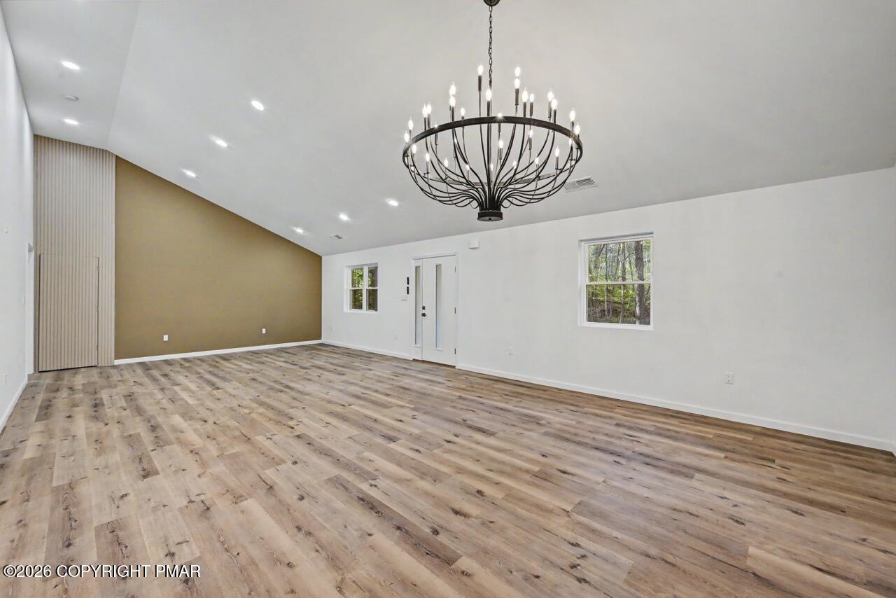 1131 Mink Court Bushkill, PA 18324 - Photo 25 of 81 a view of empty room with wooden floor and chandelier