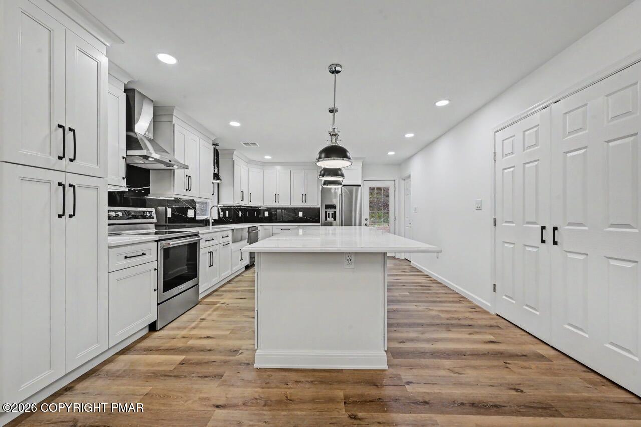 1131 Mink Court Bushkill, PA 18324 - Photo 28 of 81 a kitchen with stainless steel appliances kitchen island granite countertop a stove a sink and a refrigerator