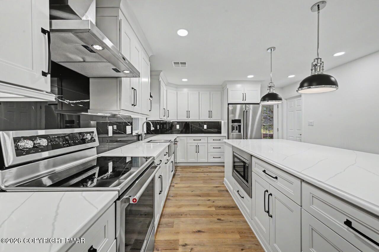 1131 Mink Court Bushkill, PA 18324 - Photo 34 of 81 a large kitchen with stainless steel appliances granite countertop a stove a sink and a refrigerator