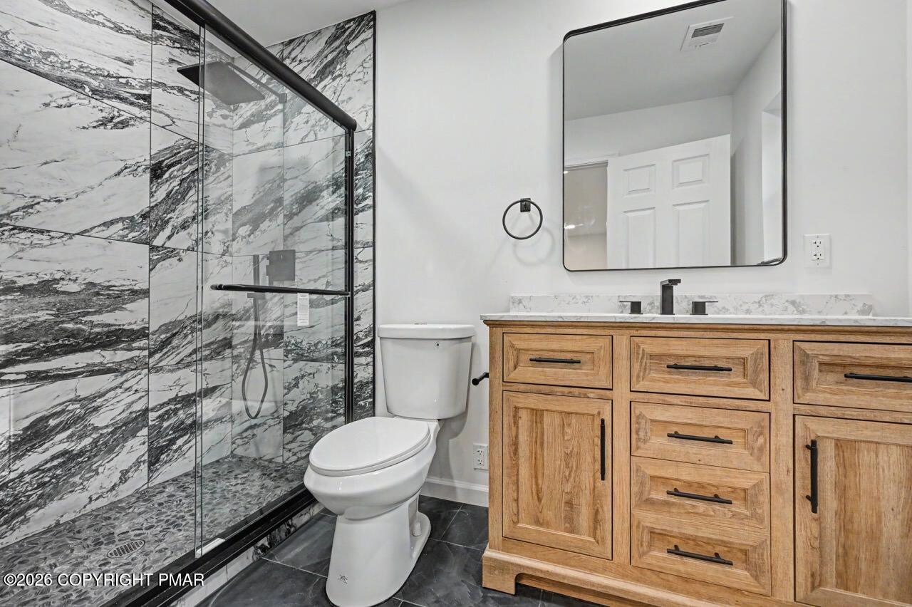 1131 Mink Court Bushkill, PA 18324 - Photo 40 of 81 a bathroom with a granite countertop toilet sink and a mirror
