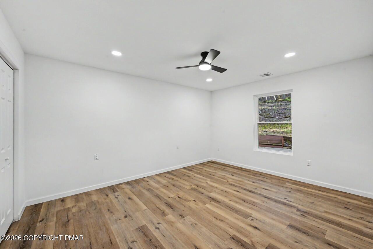 1131 Mink Court Bushkill, PA 18324 - Photo 43 of 81 wooden floor in an empty room with a window